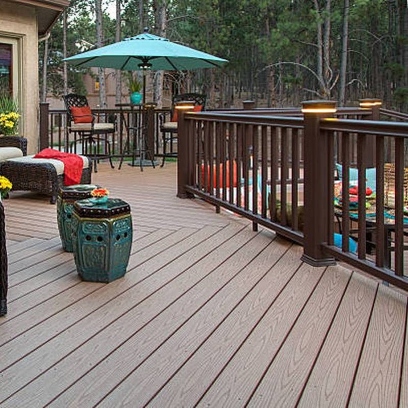 Beautiful backyard deck with built-in lighting and fully decorated with vibrant and colorful furniture and decor